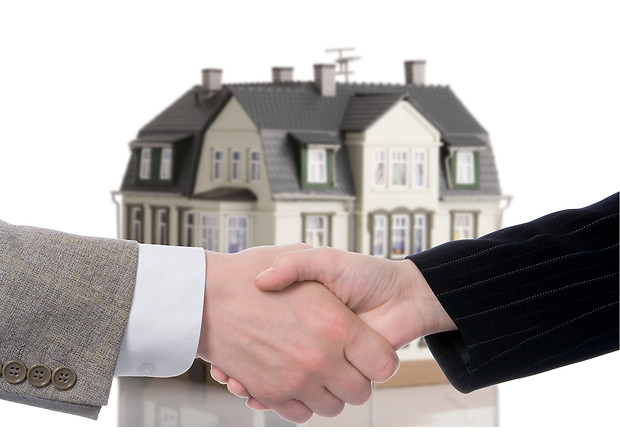 handshake arrangement buying - selling of house over white background
